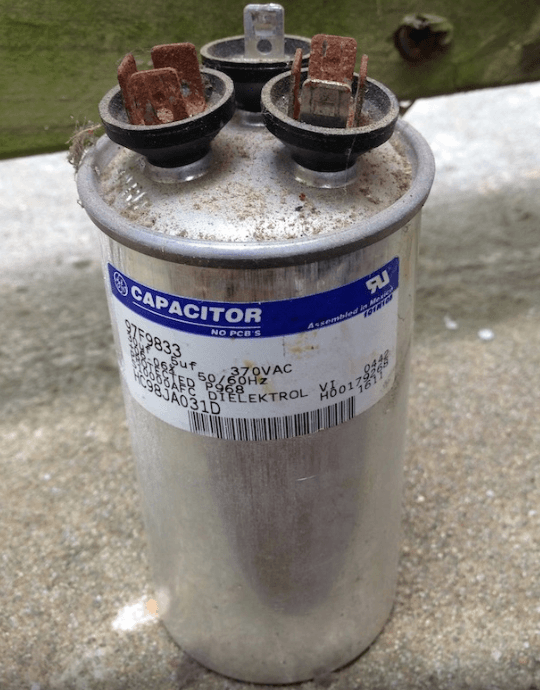 Failed HVAC dual-run capacitor with bulged, corroded terminals